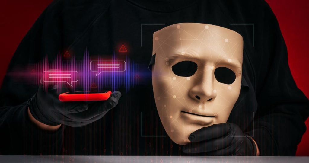Una persona con guantes sostiene una máscara con puntos de escaneo facial y un móvil que muestra ondas de voz