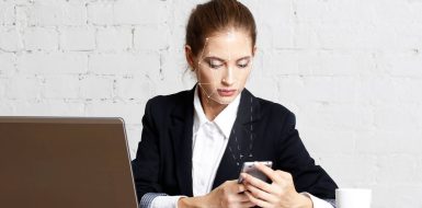Una mujer en su oficina utiliza su teléfono móvil con una rejilla de reconocimiento facial sobre su rostro